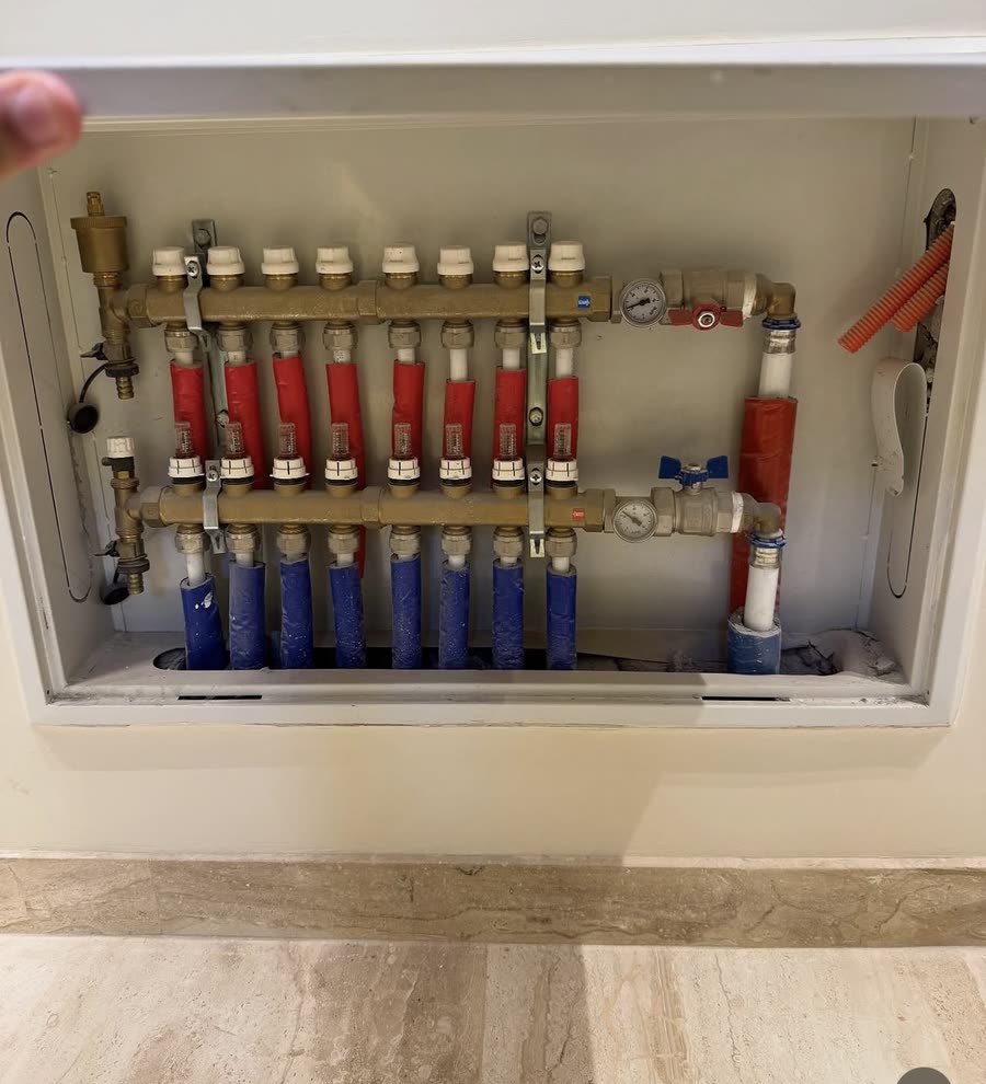 Labelled water manifold photographed on a ZAN site before closing the wall